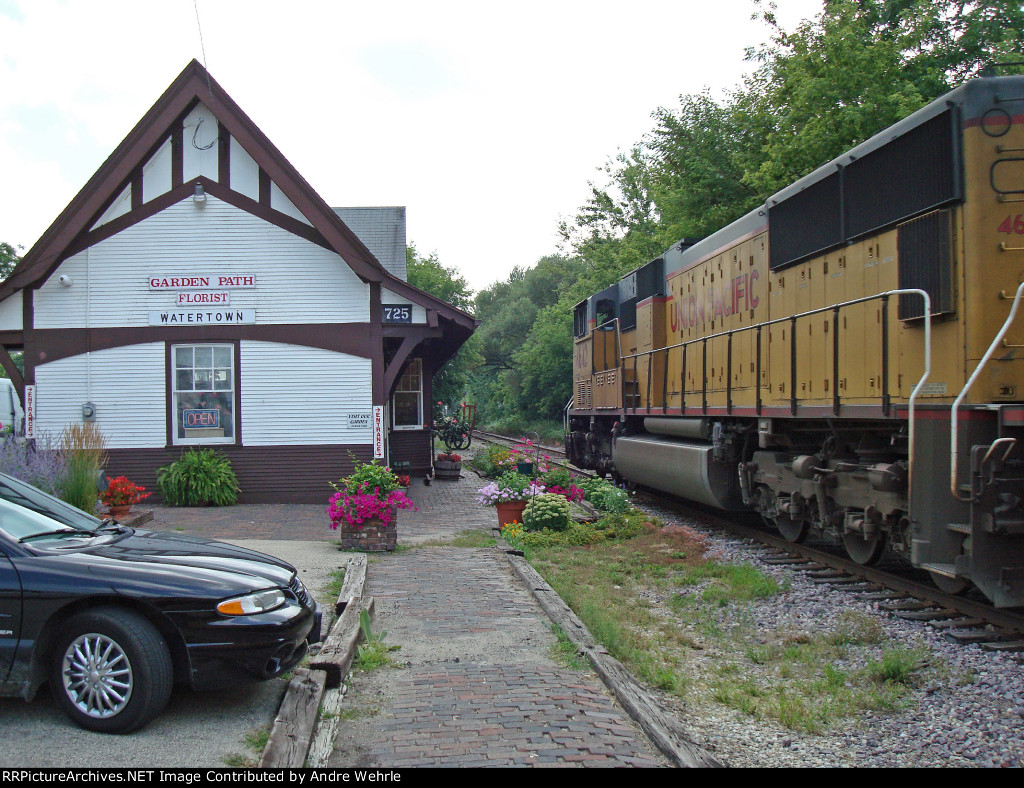 UP 4642 passing the old C&NW depot, now a flower shop